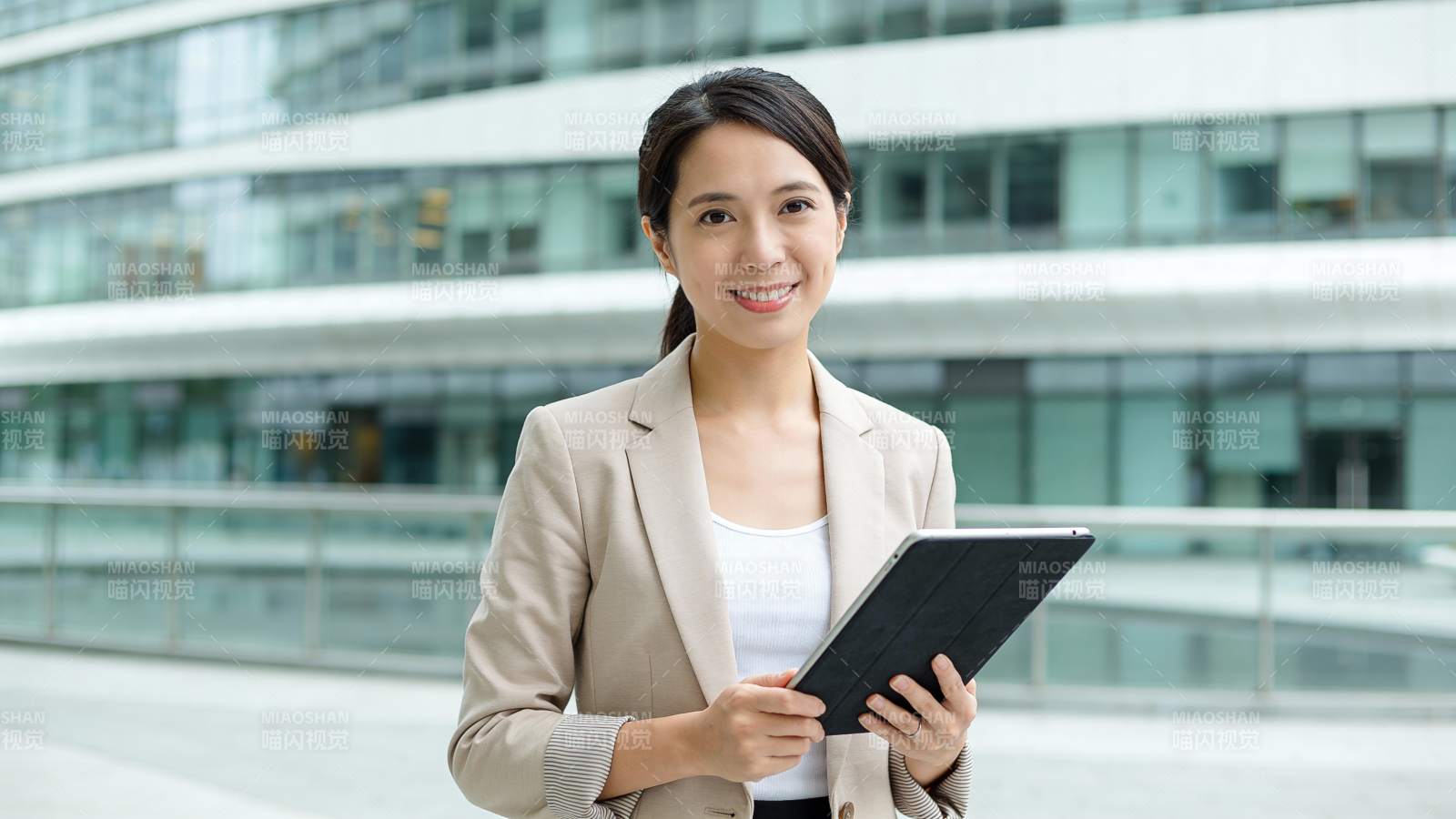 职场女性持平板微笑站立图片