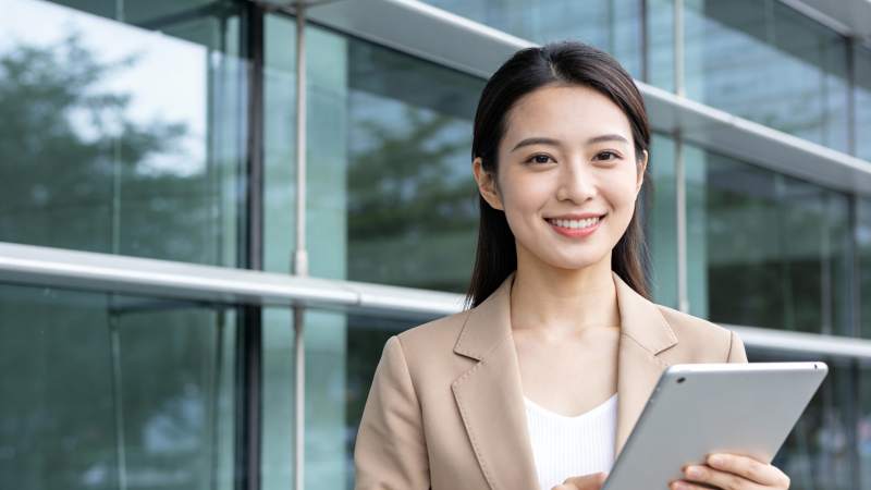 职场女性持平板微笑站立图片