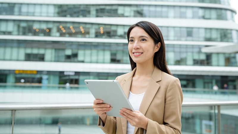 商务女性持平板微笑望远图片