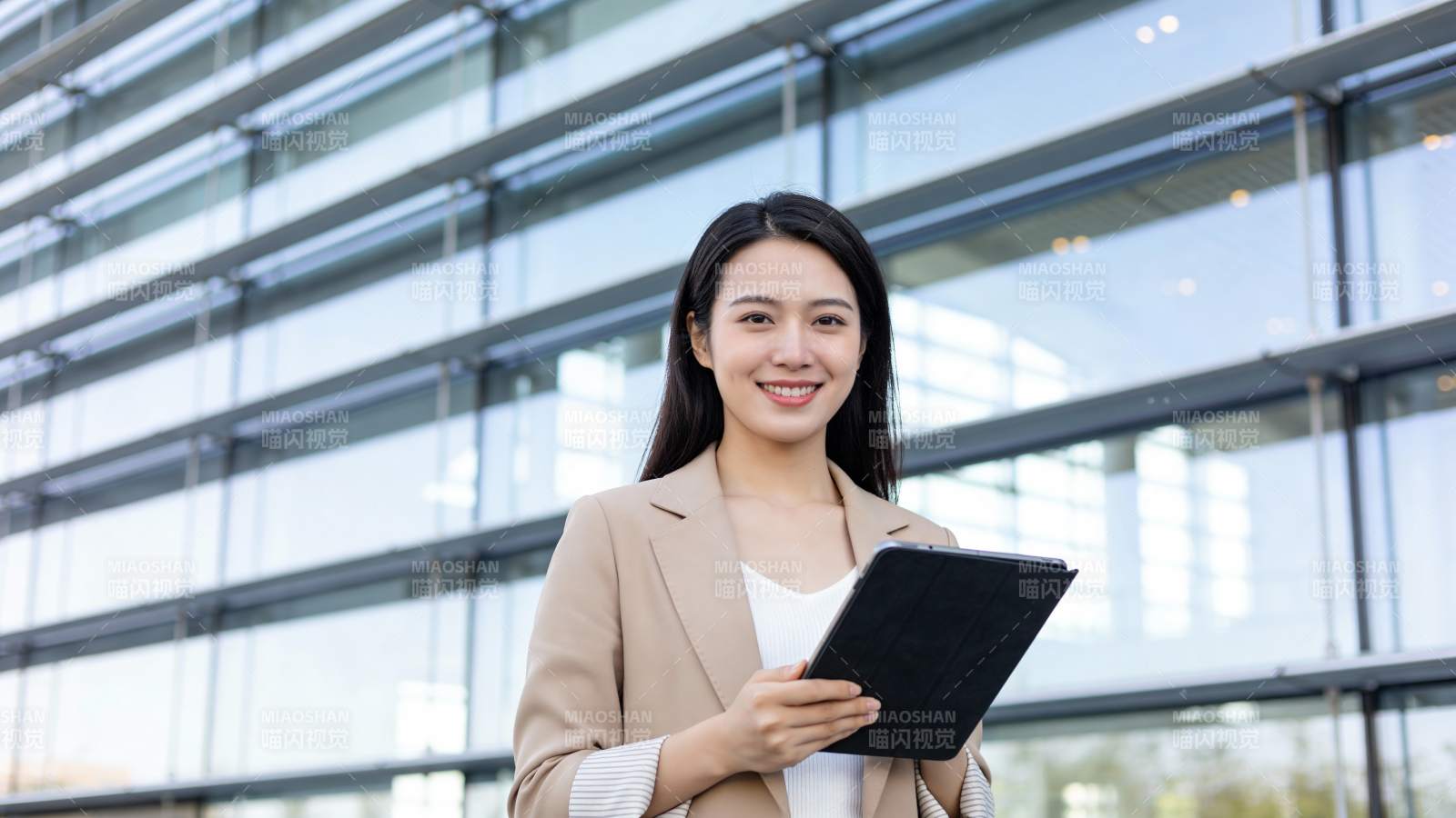 职场女性持平板微笑站立图片