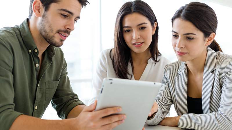 三人共看平板讨论中图片