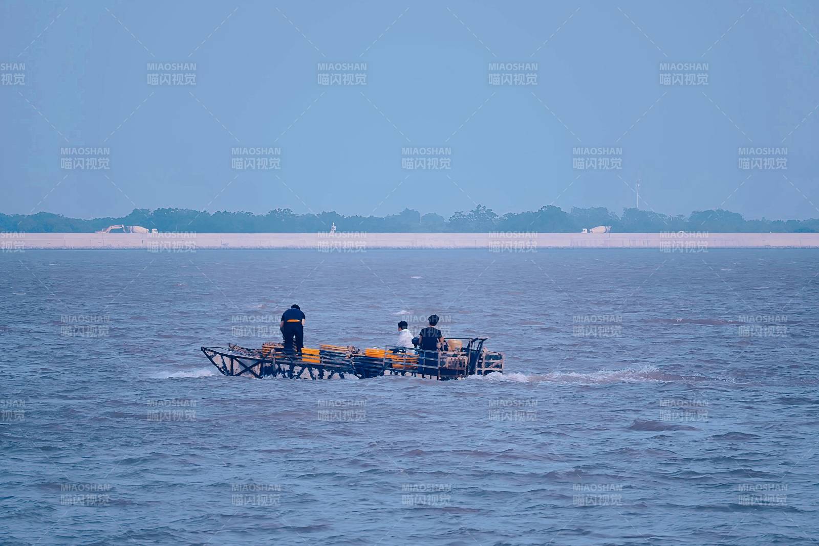 三人乘船行于水面图片