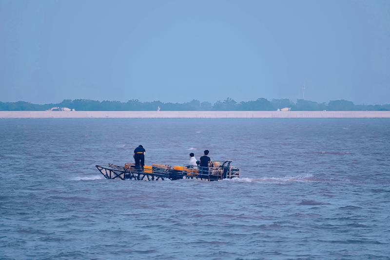 三人乘船行于水面图片