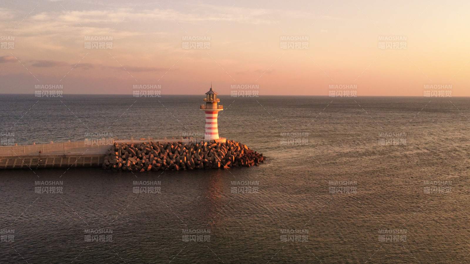 夕阳下的灯塔守望大海图片