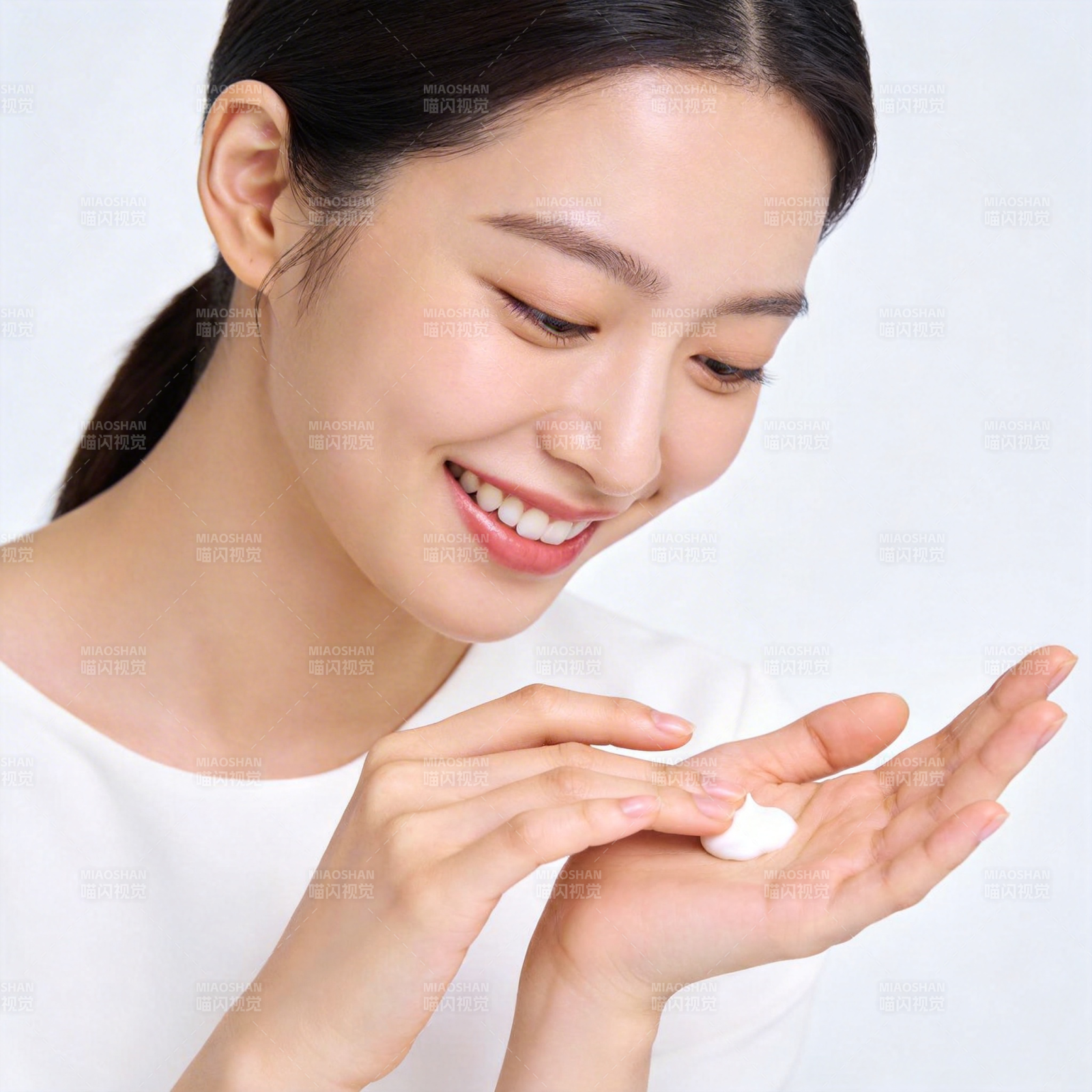 微笑女子轻触掌心乳霜图片