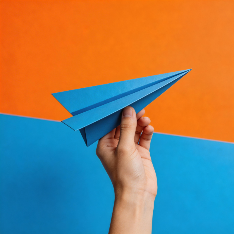 手握蓝纸飞机 橙蓝背景鲜明图片