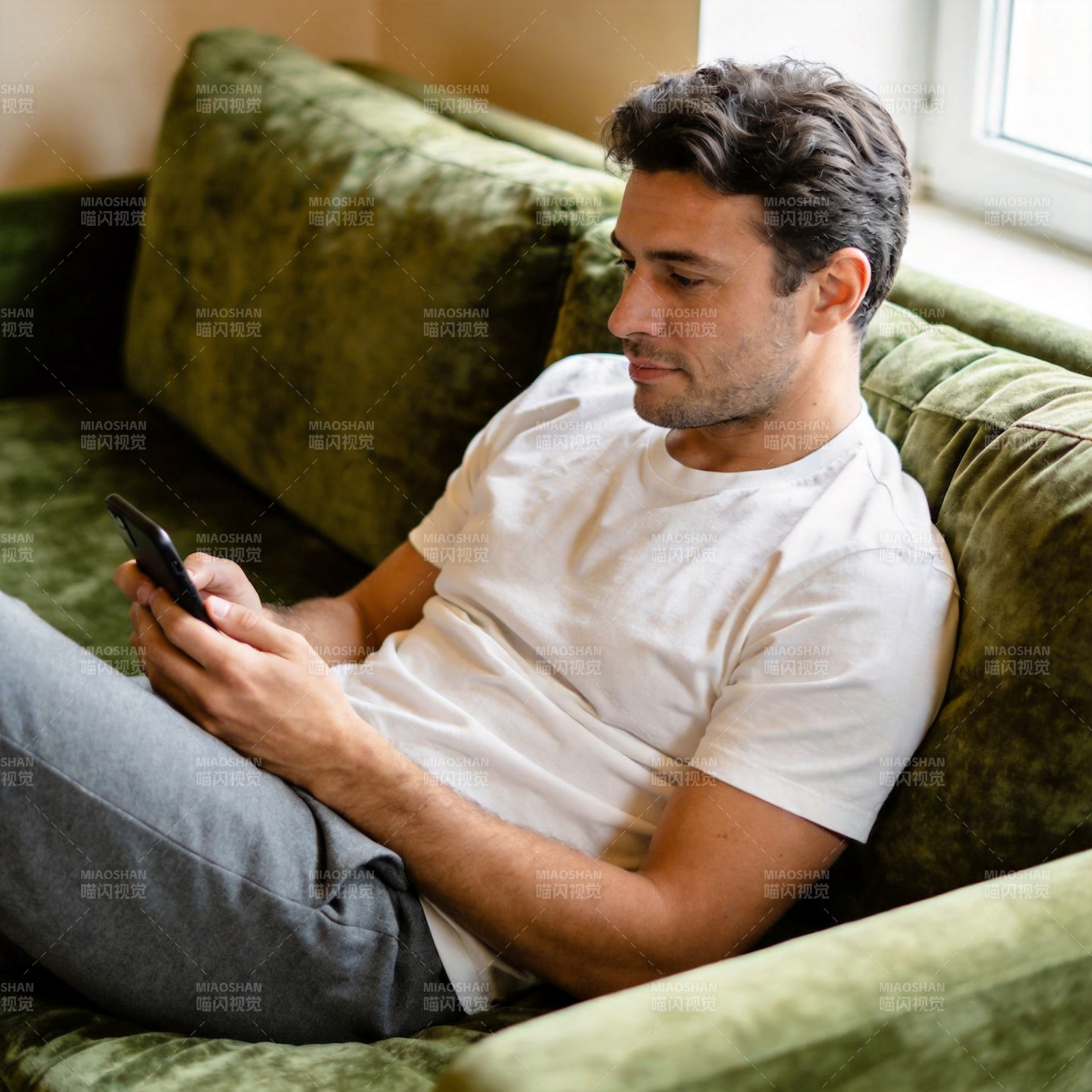 沙发上看手机的男子图片