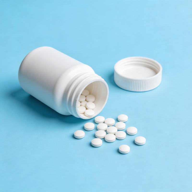 药瓶倾倒 白色药片散落蓝底图片