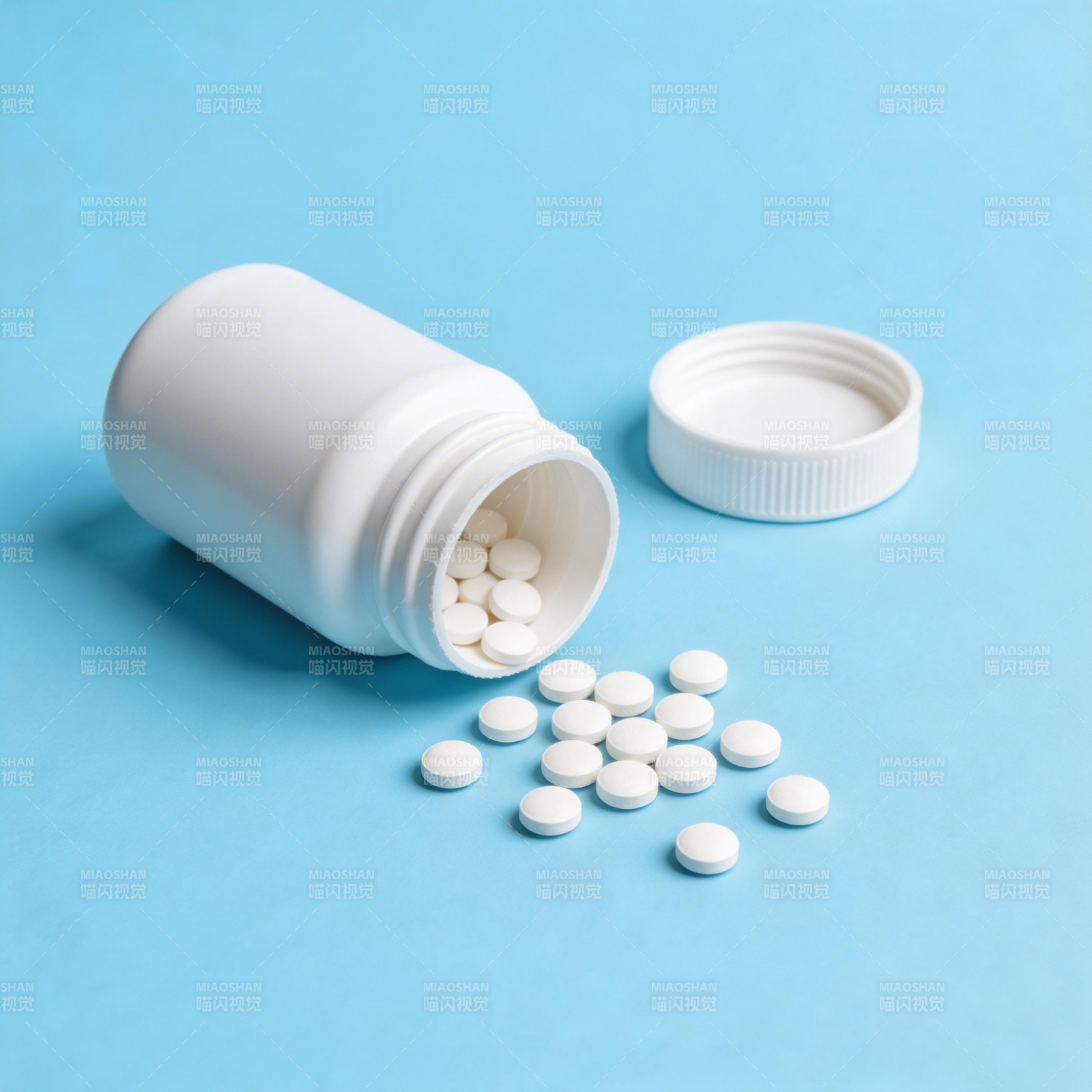 药瓶倾倒 白色药片散落蓝底图片