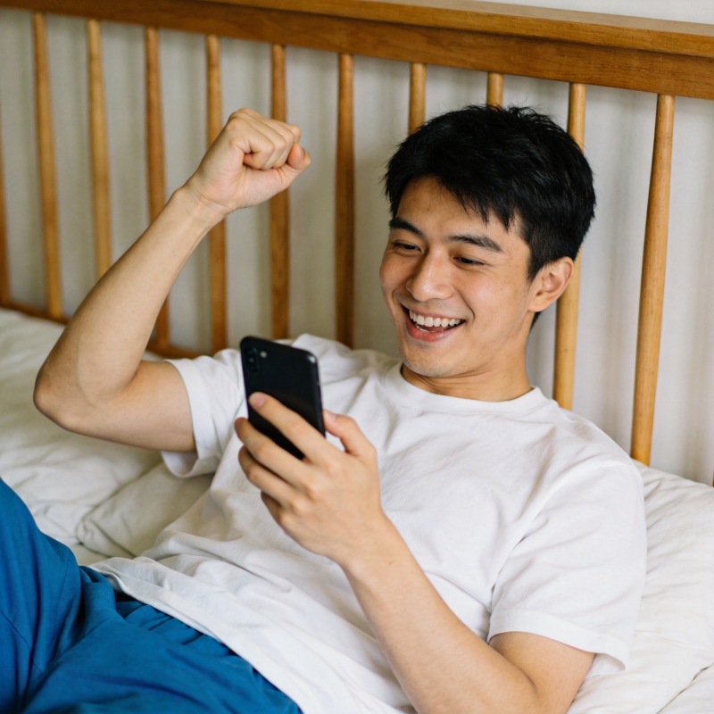 床上看手机 开心握拳笑图片