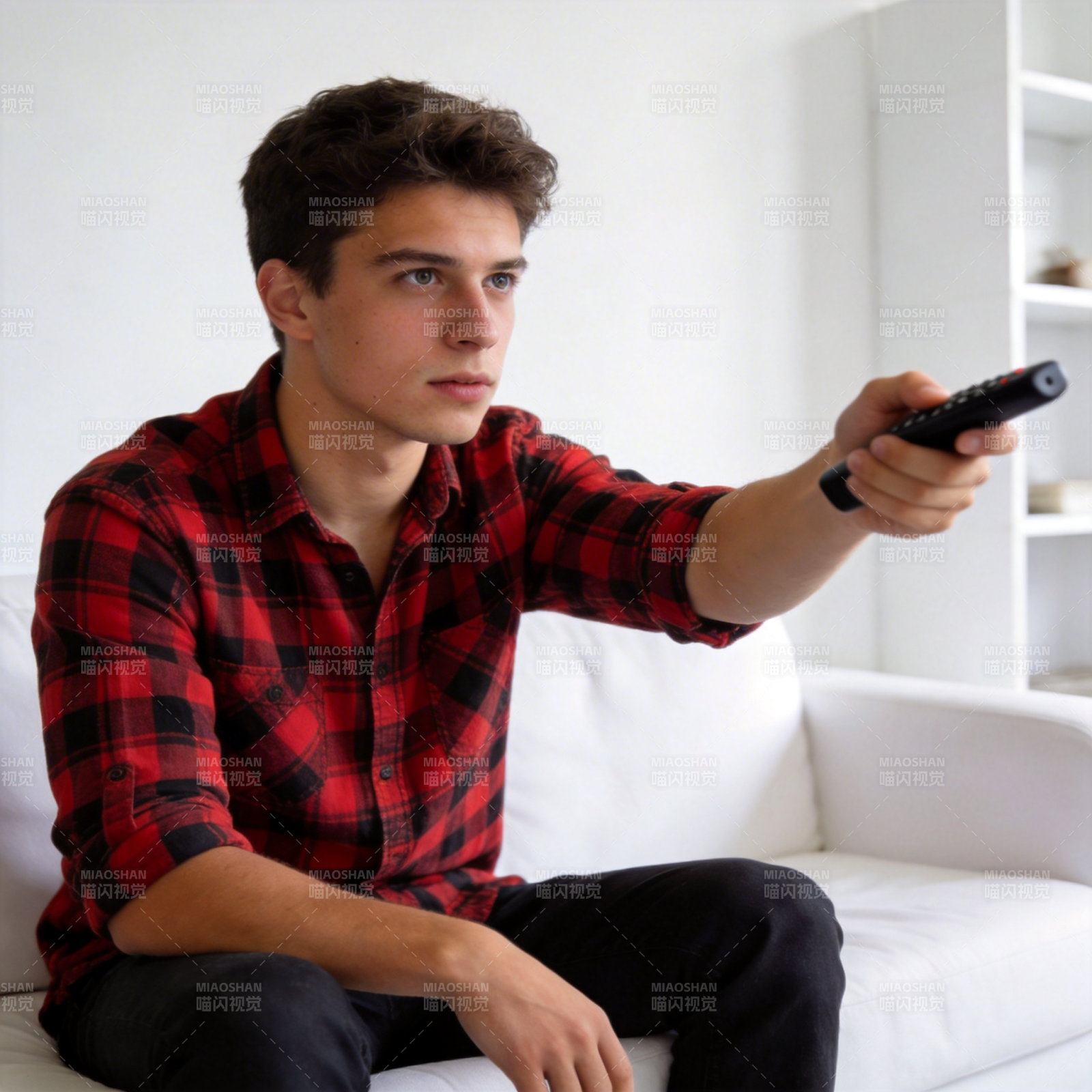 青年持遥控器坐沙发看电视图片
