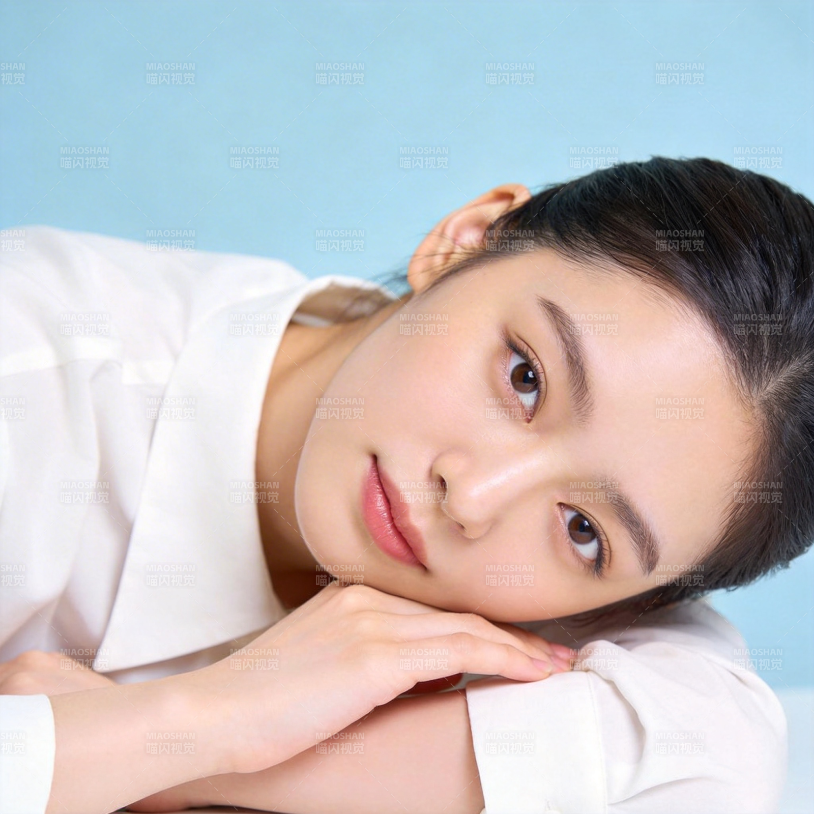 白衣少女托腮凝望蓝背景图片