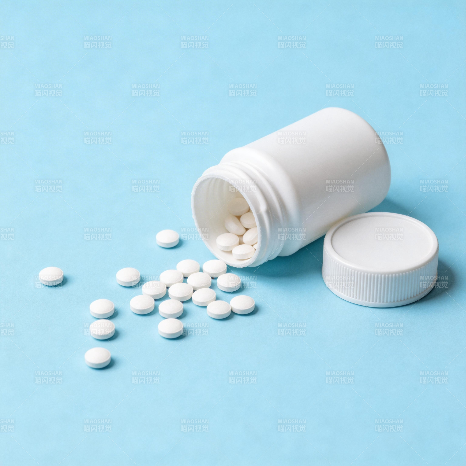 药瓶倾倒 白色药片散落蓝底图片
