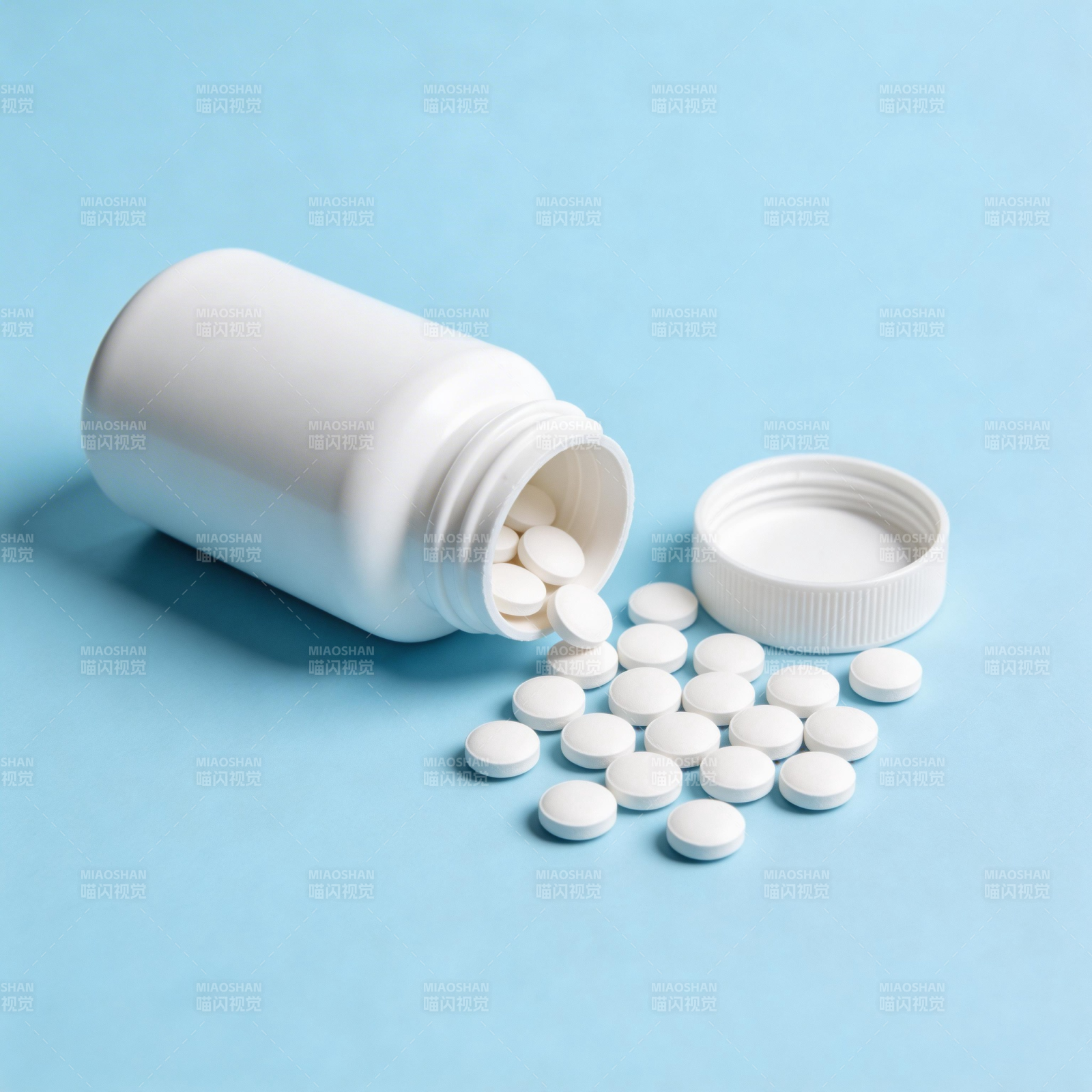 药瓶倾倒 白色药片散落蓝底图片
