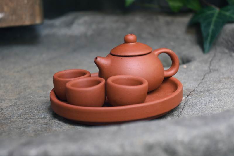 紫砂茶具静置石上图片