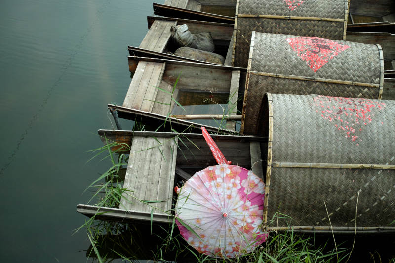 竹篓旁 花伞静卧水边草图片