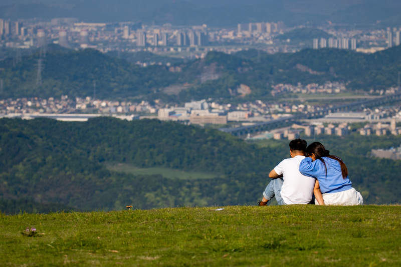 山顶情侣眺望远方城市图片