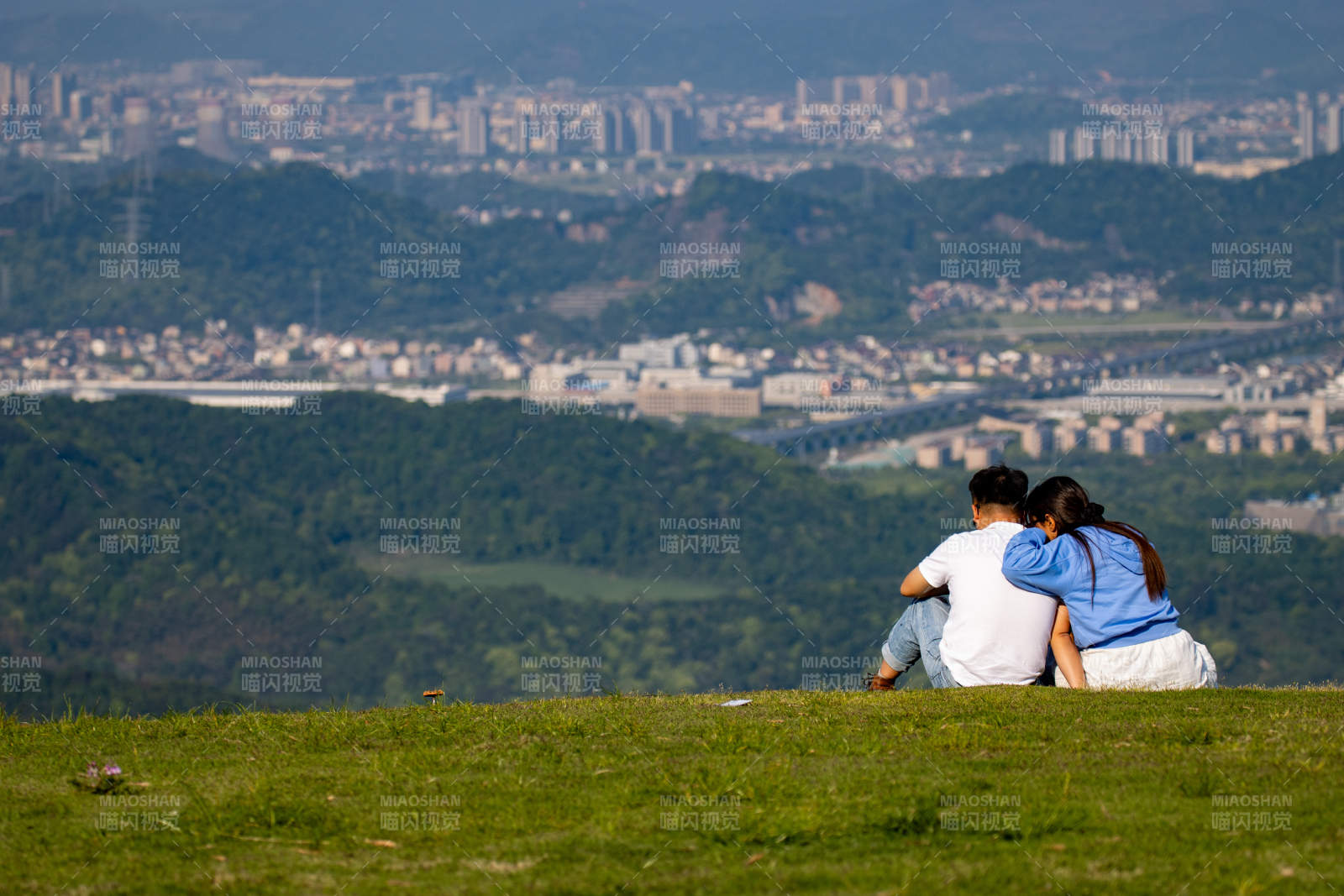 山顶情侣眺望远方城市图片