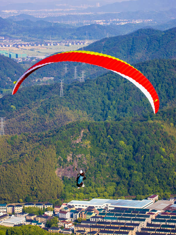 滑翔伞飞越青山小镇图片