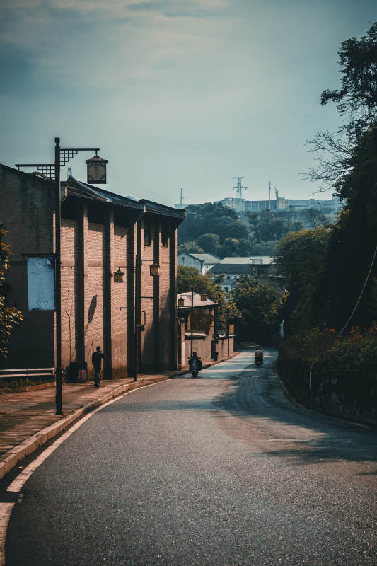 老街斜阳 摩托轻驰远山间图片