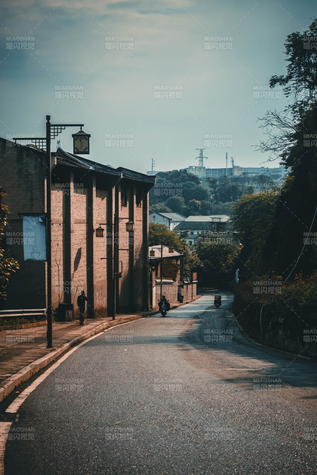 老街斜阳 摩托轻驰远山间图片