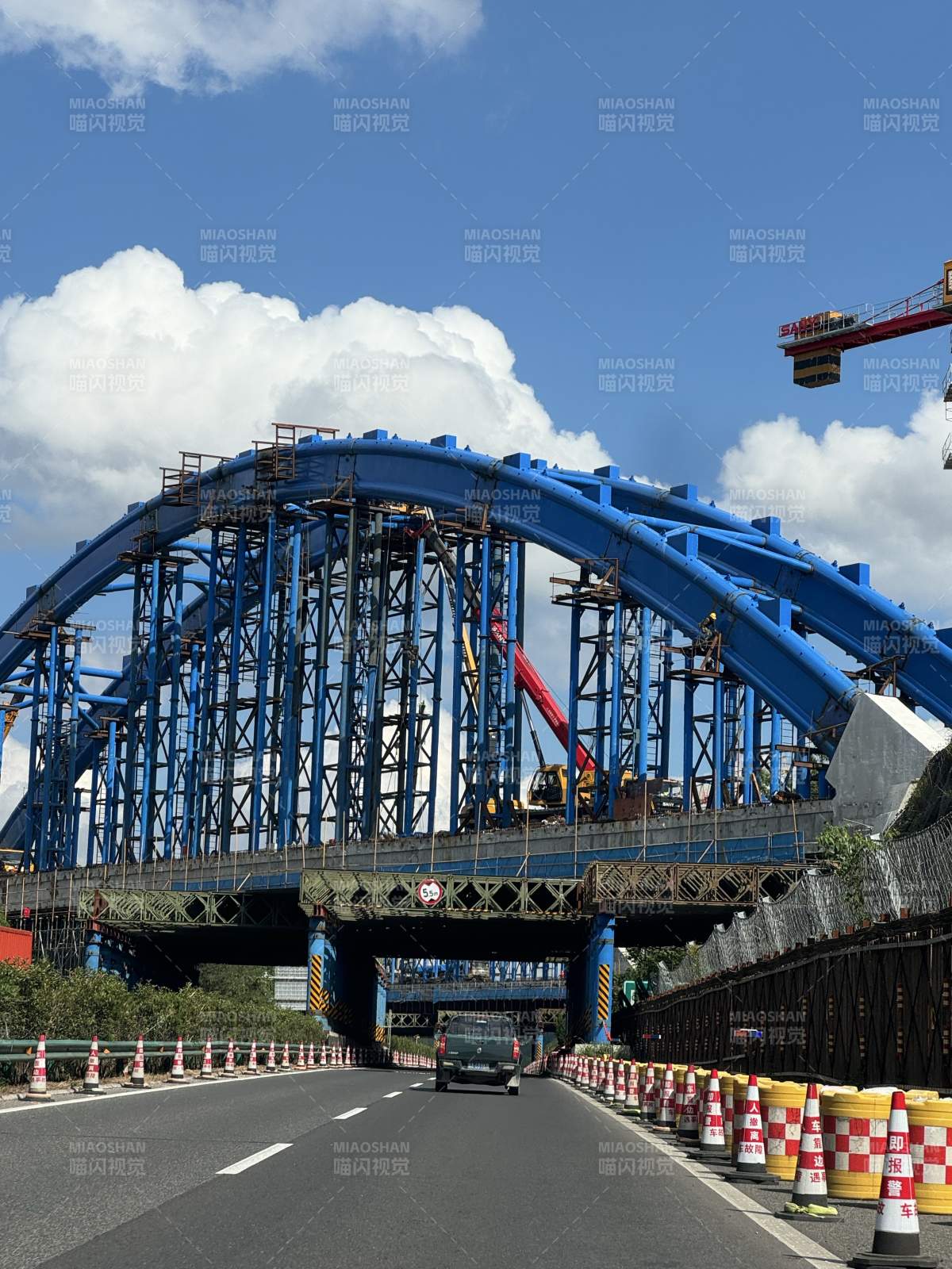 蓝天白云下的蓝色拱桥施工中图片