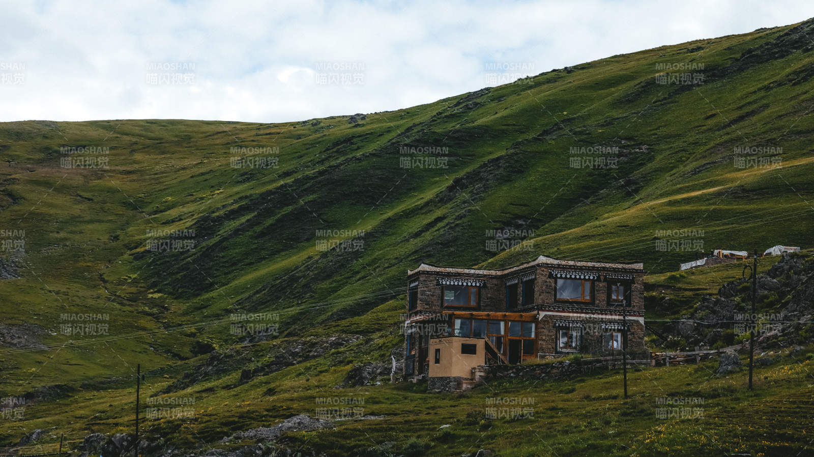 川西山间藏式小屋静立绿坡图片