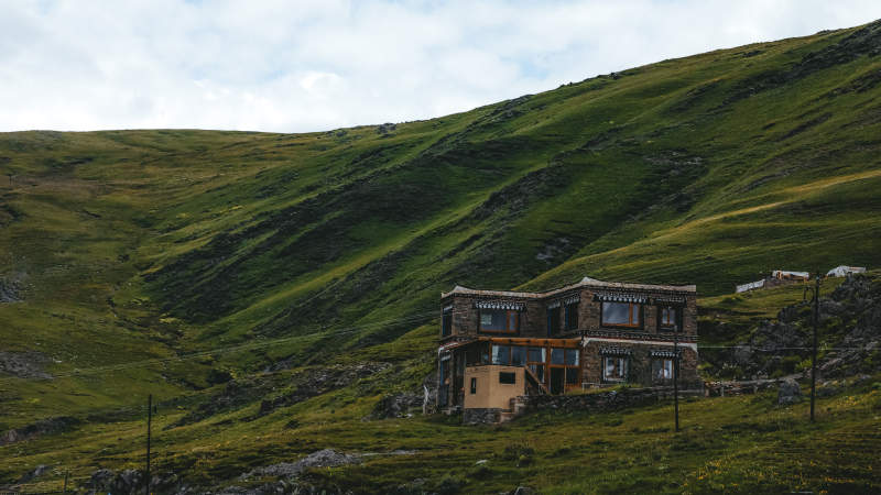 山间藏式小屋静立绿坡图片