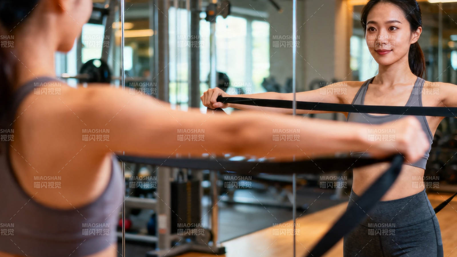 女子健身房拉弹力带训练图片