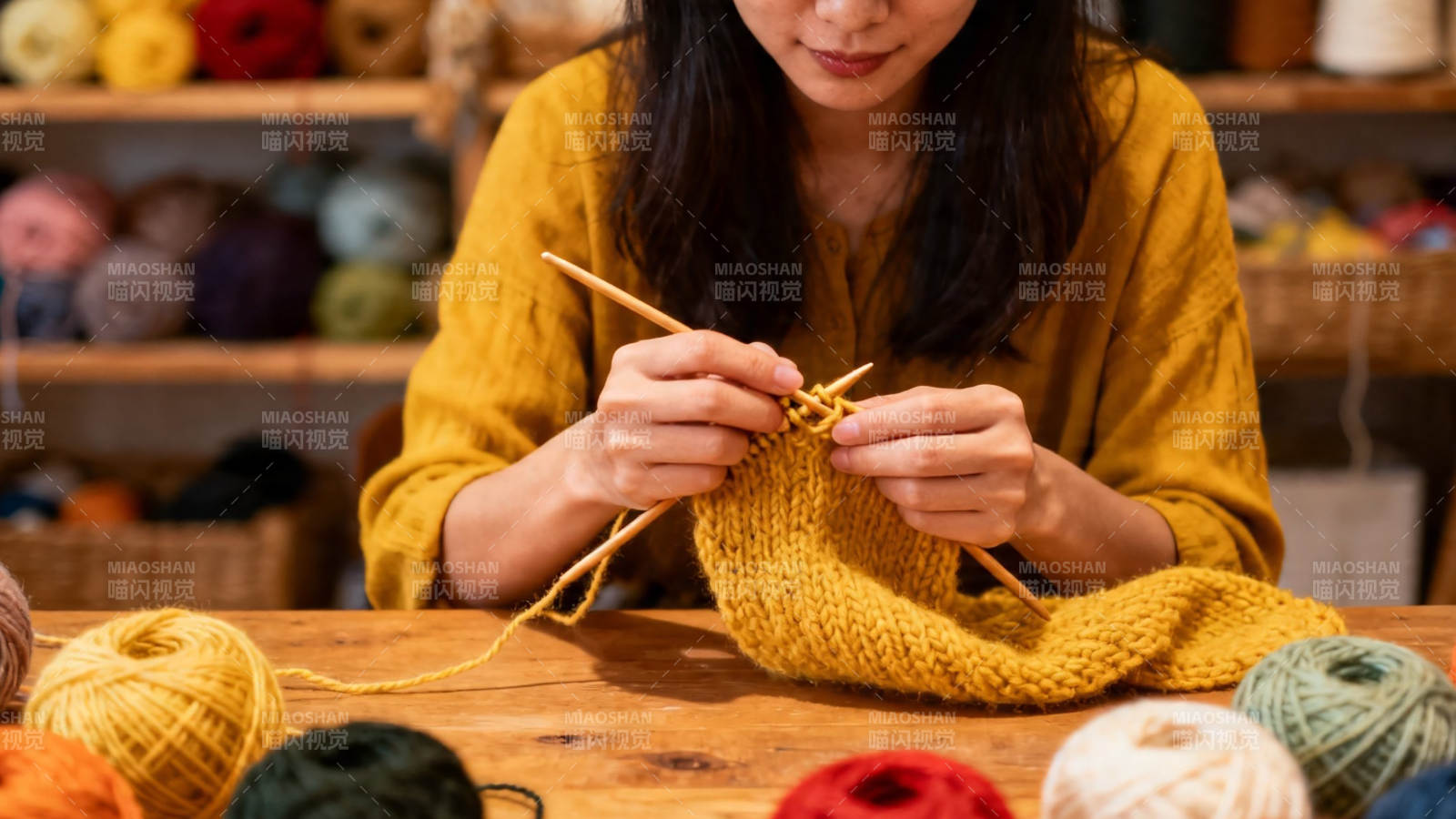 女子专注编织黄色毛衣图片