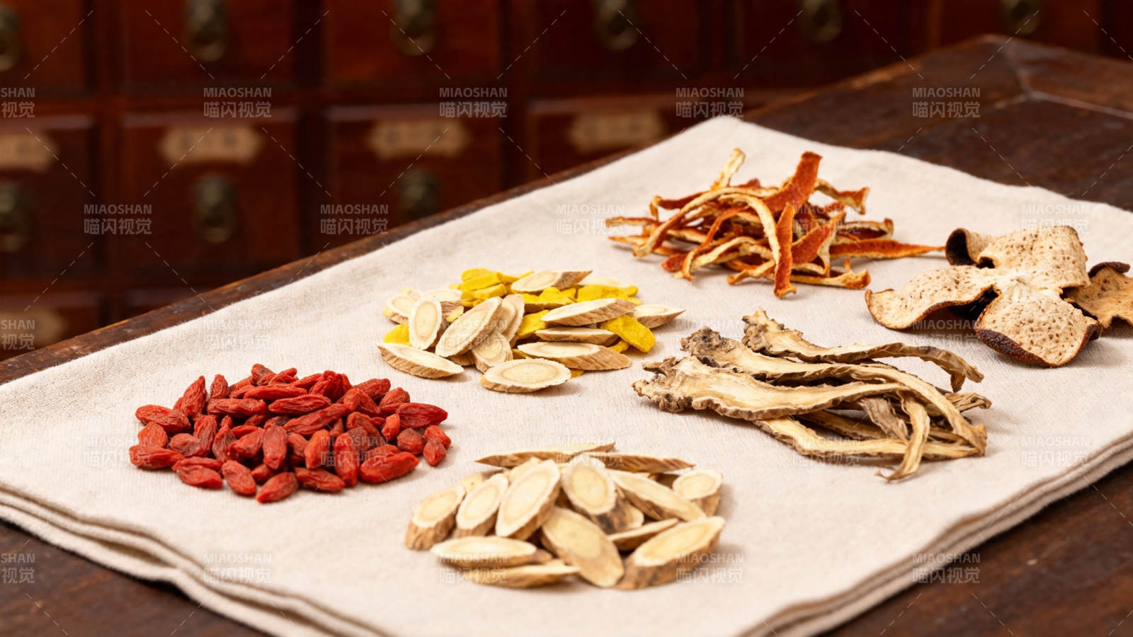 中药材陈列于布上 背景药柜图片