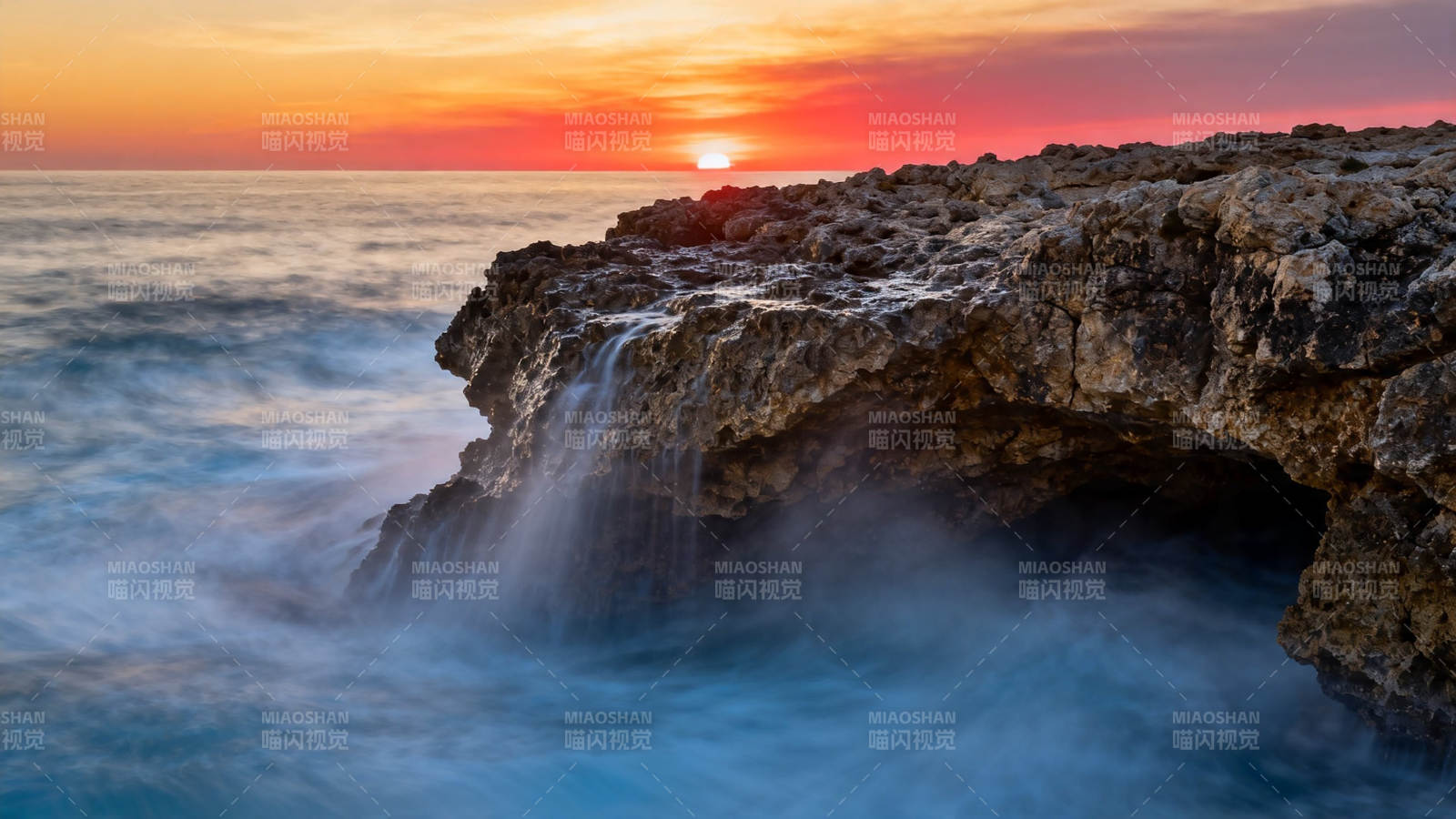夕阳海浪拍岩洞图片