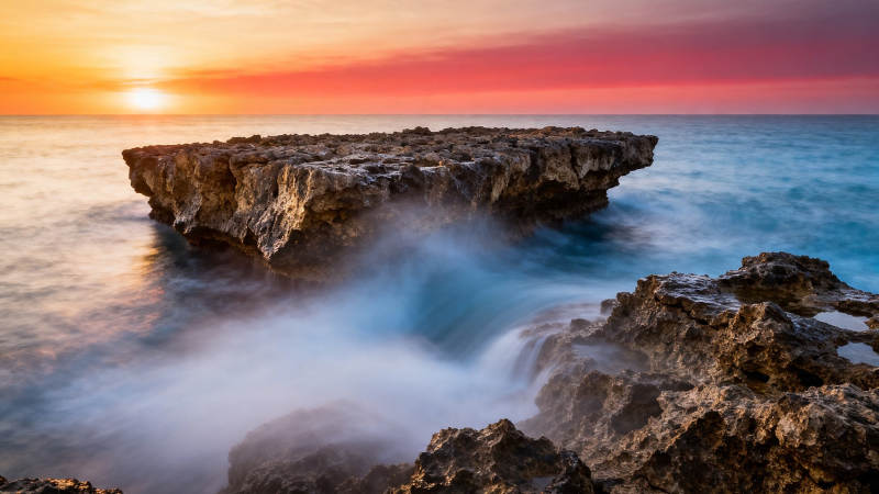 日落礁石 海浪轻抚岩岸图片