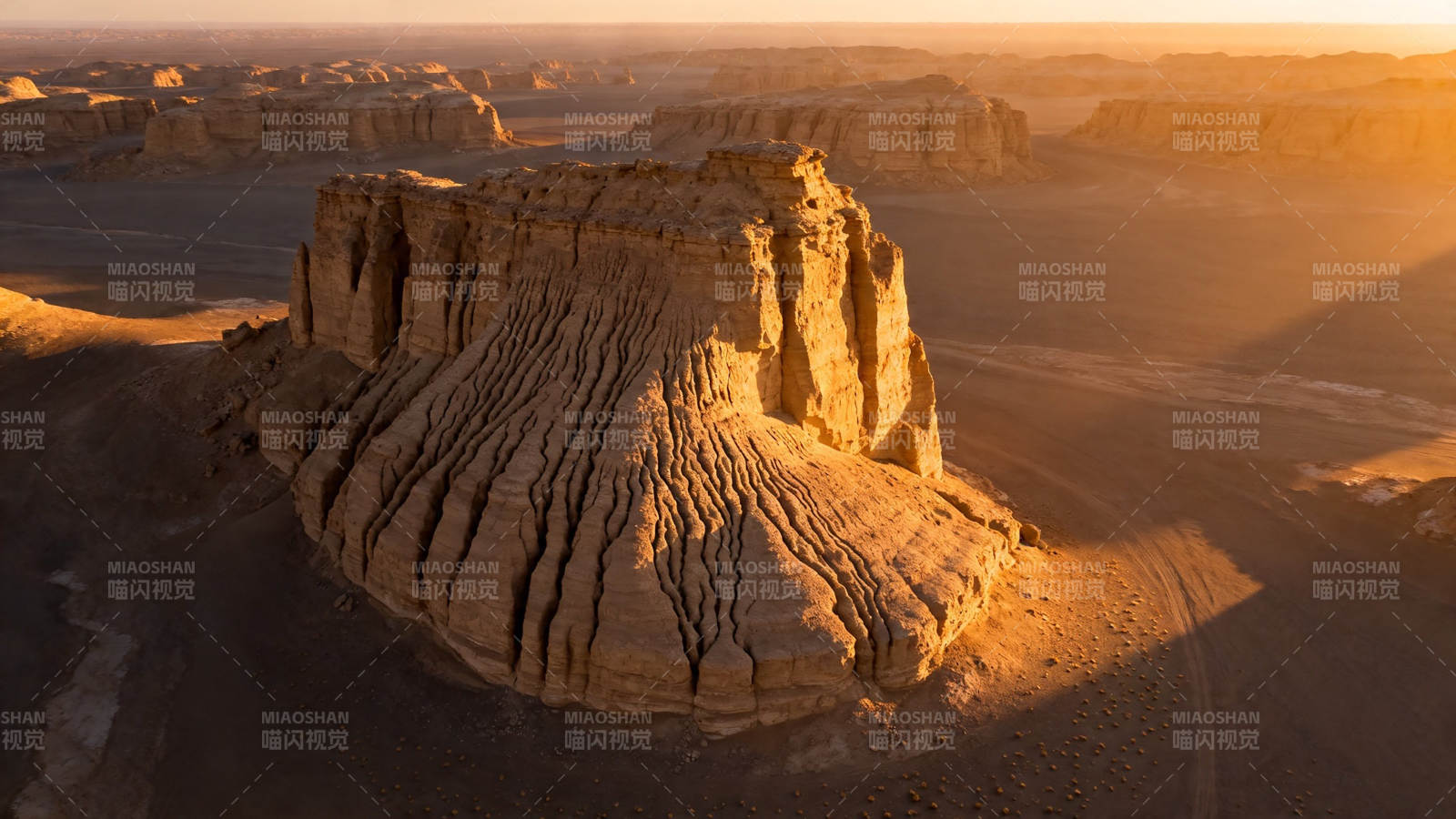 沙漠孤峰 夕阳金辉照岩壁图片