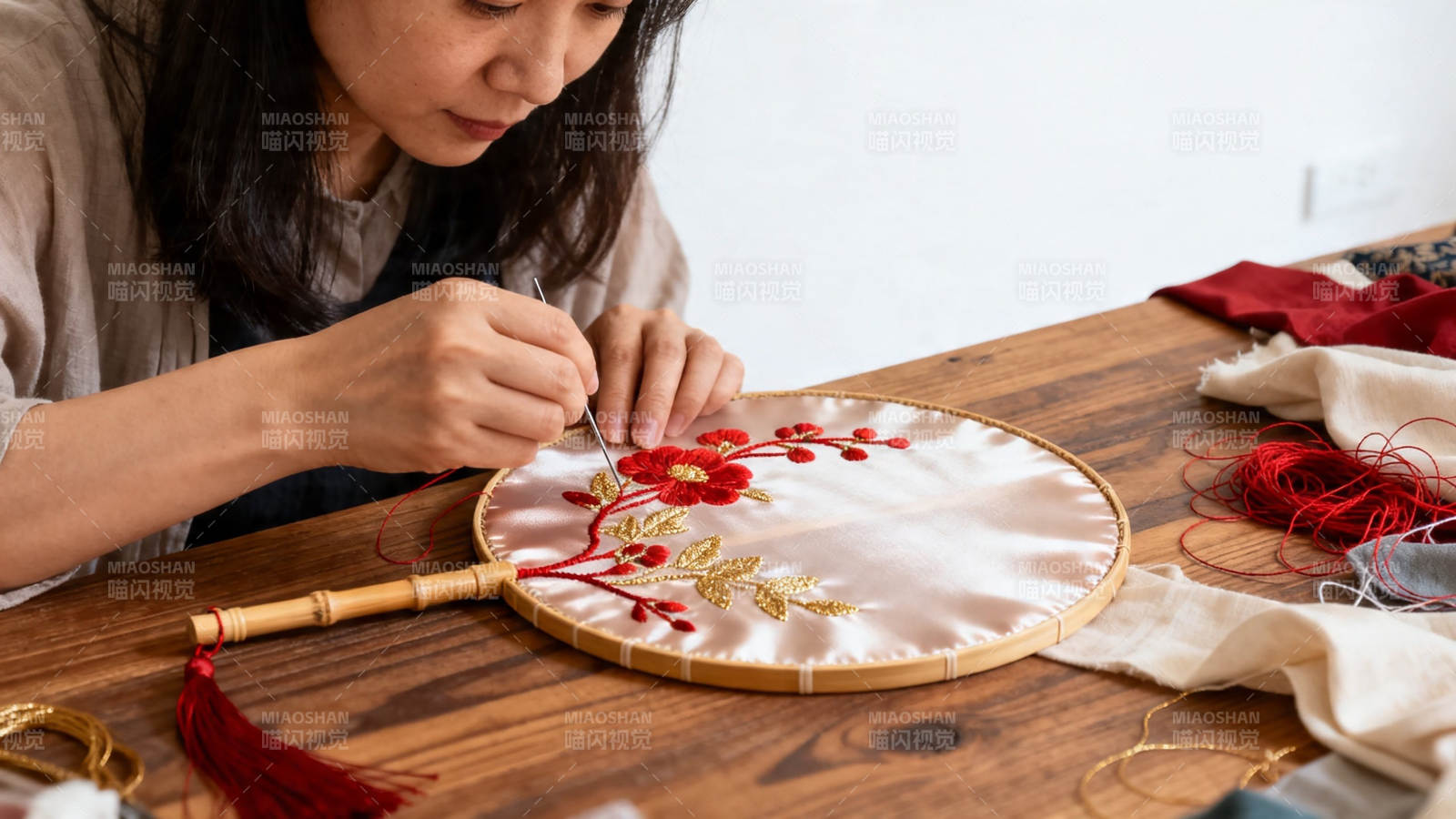 女子专注刺绣红花金叶图片