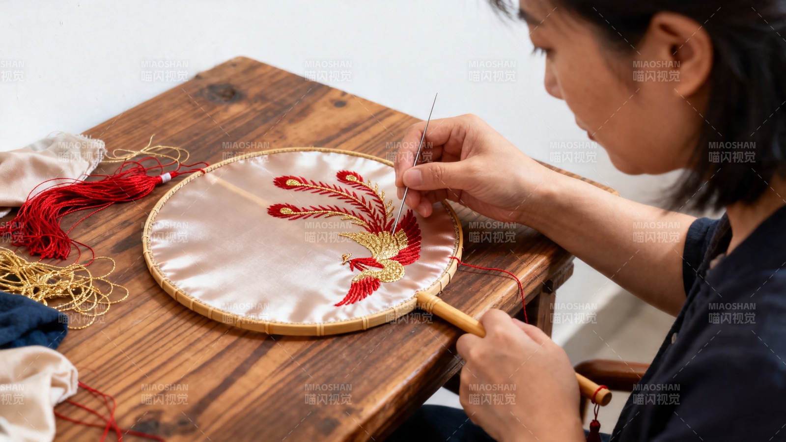 女子专注刺绣凤凰图案图片