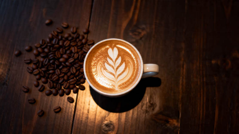 咖啡拉花与豆香木桌情调图片