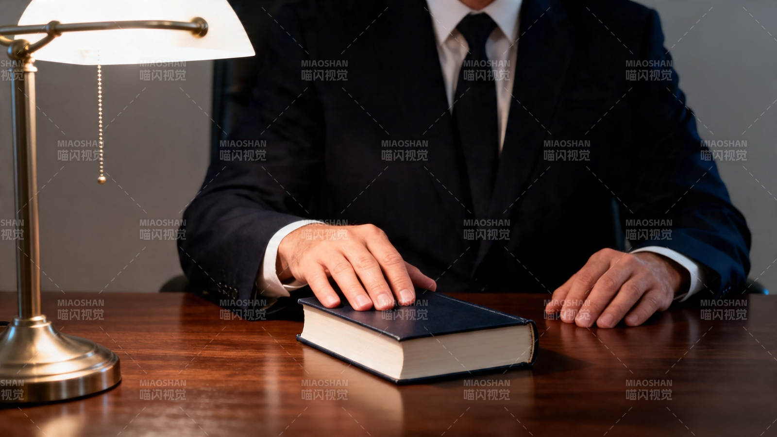 律师桌前手按法典图片