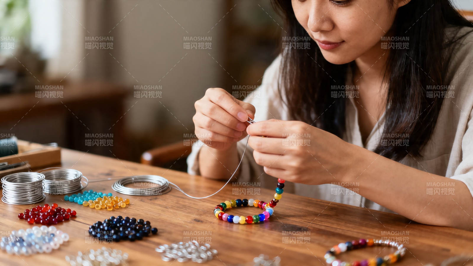 女子专注串珠做手链图片