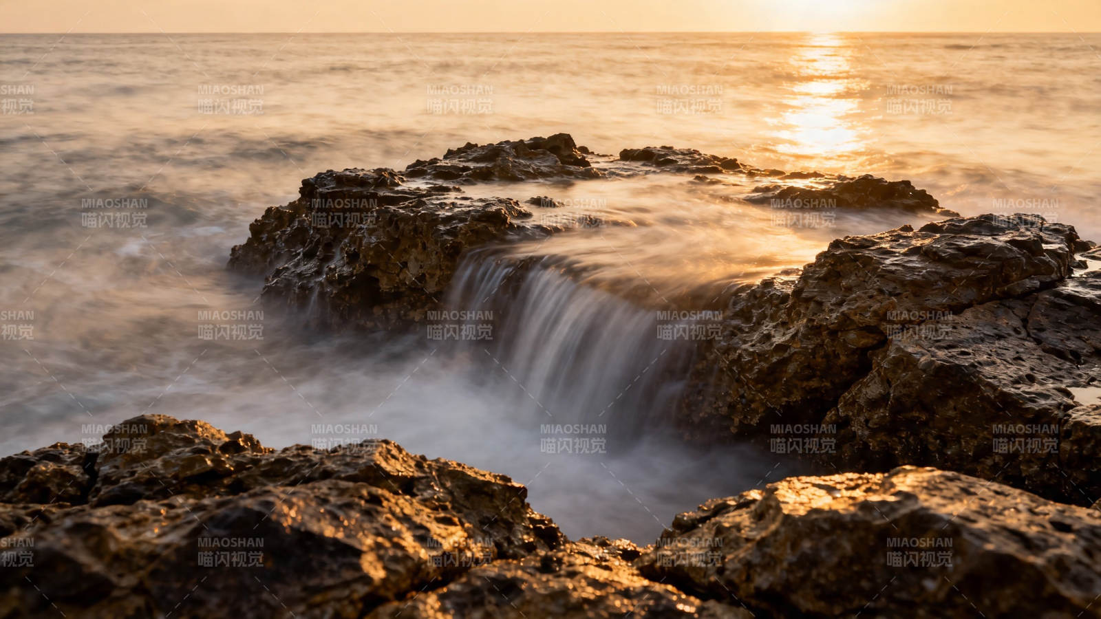 夕阳海浪拍礁石图片