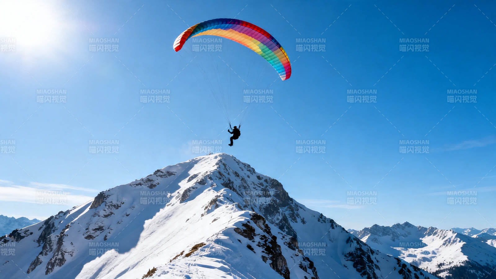 雪山之巅彩虹伞飞翔图片