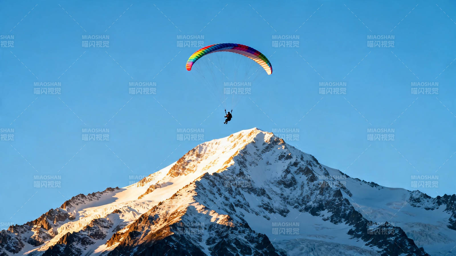 雪山之巅彩虹滑翔伞图片