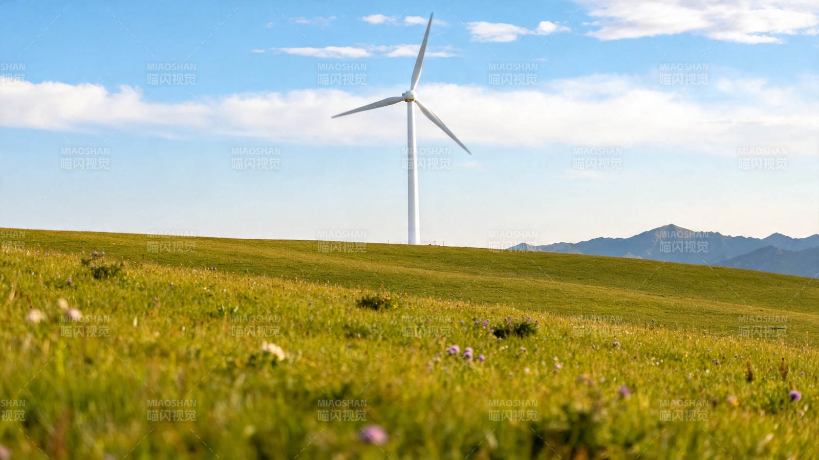 风车矗立绿野蓝天间图片