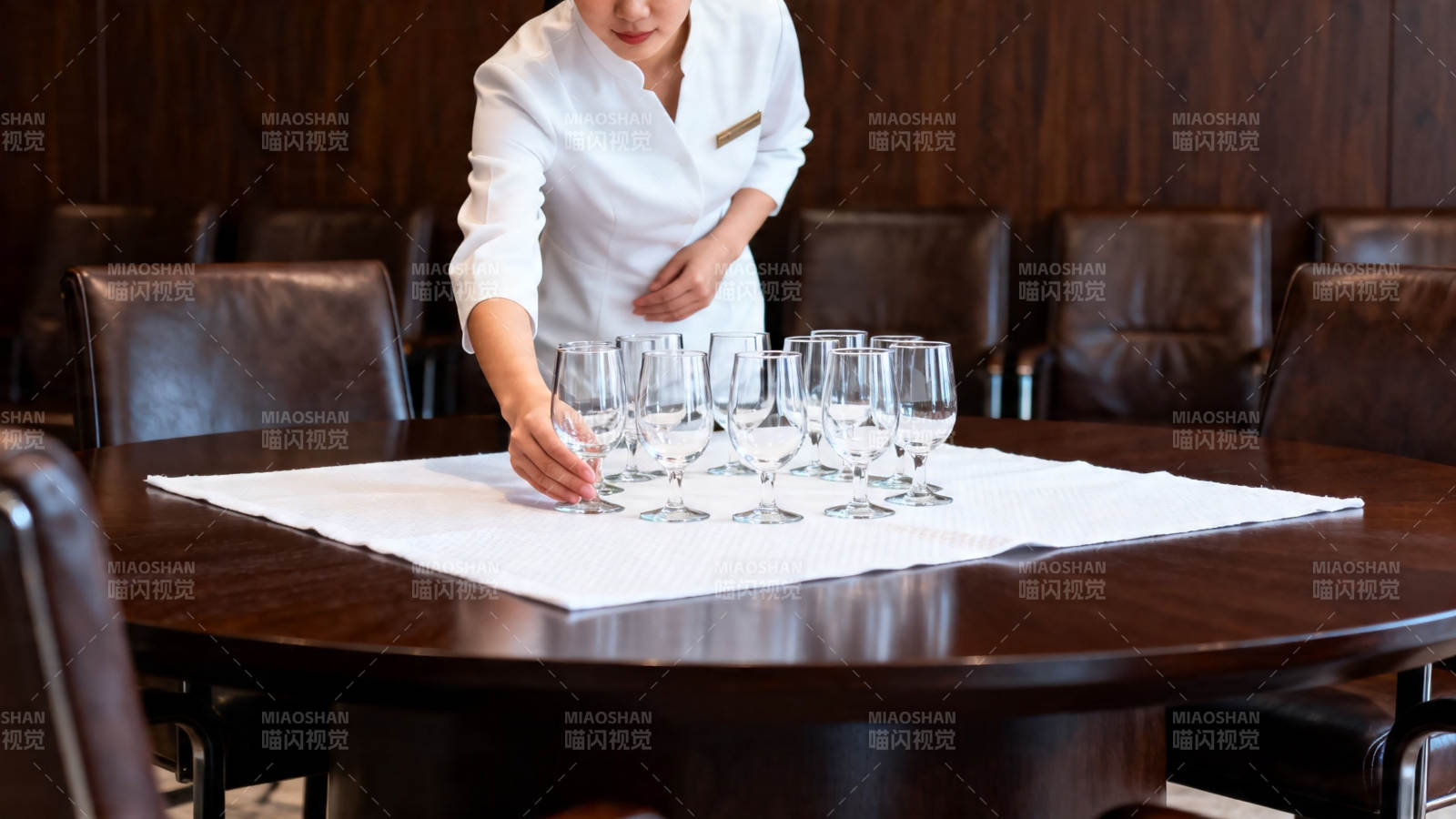 服务员摆酒杯于圆桌图片