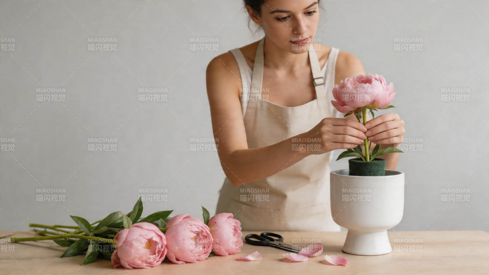 女子插花 粉牡丹入白盆图片