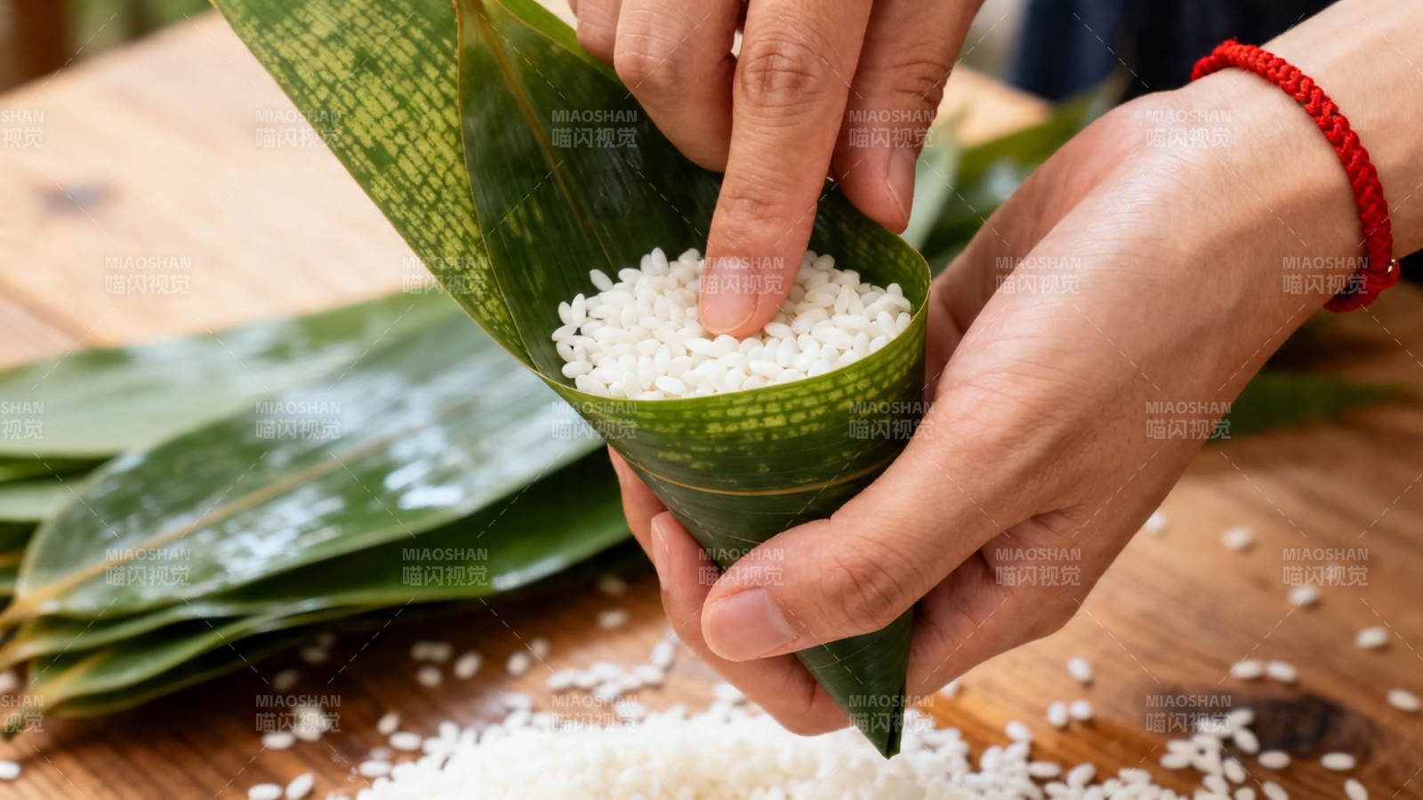 包粽子 手填糯米入粽叶图片