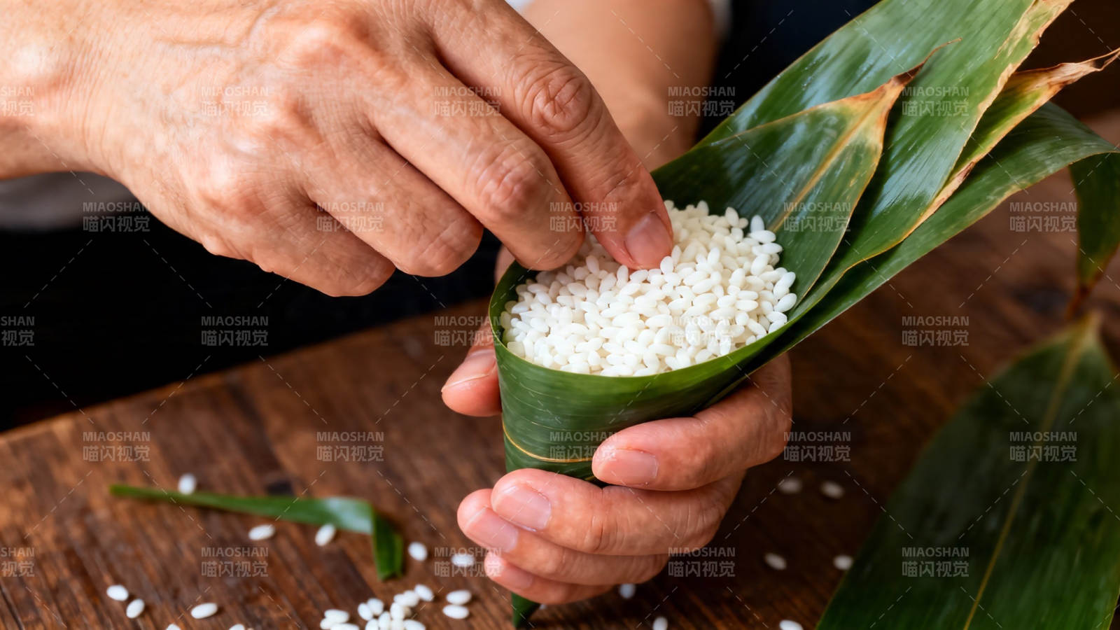 手工包粽子 糯米入叶中图片