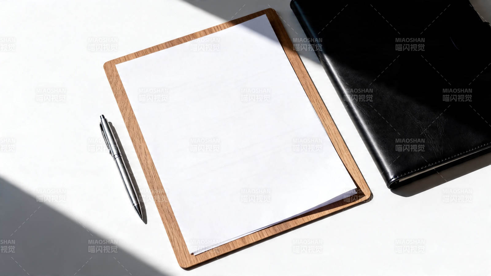 木夹板白纸笔与黑本静置桌面图片