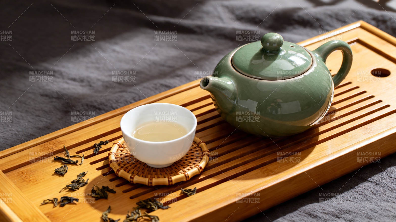 青瓷茶壶配白杯 竹盘散叶香图片