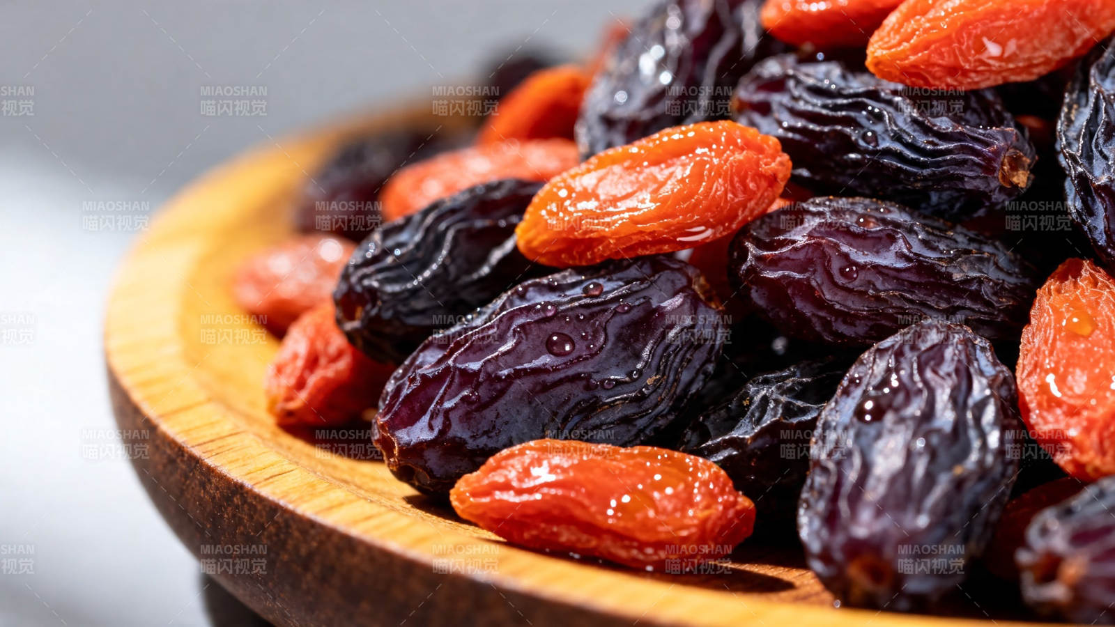 木碗盛满红黑葡萄干图片